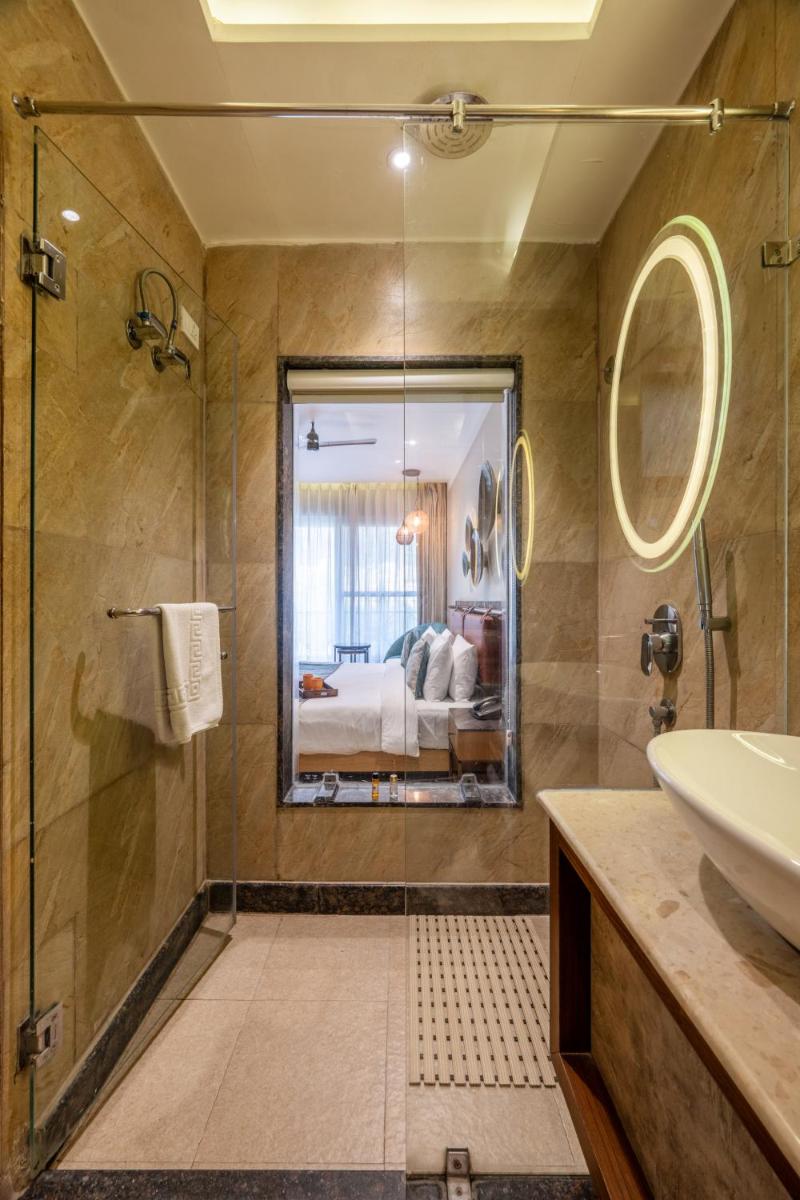 a bathroom with a shower and a sink and a bed at Antalya By Divine Ganga Cottage in Rishīkesh