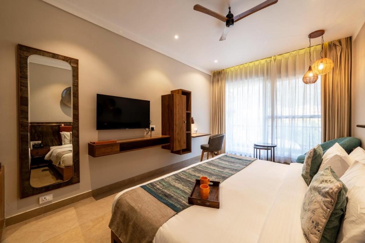 a hotel room with a bed and a mirror at Antalya By Divine Ganga Cottage in Rishīkesh