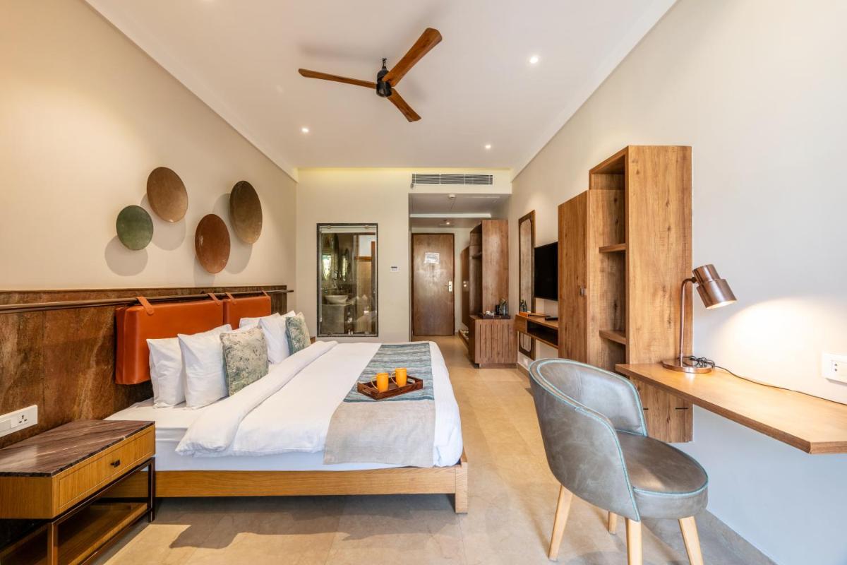 a bedroom with a bed and a desk and a chair at Antalya By Divine Ganga Cottage in Rishīkesh