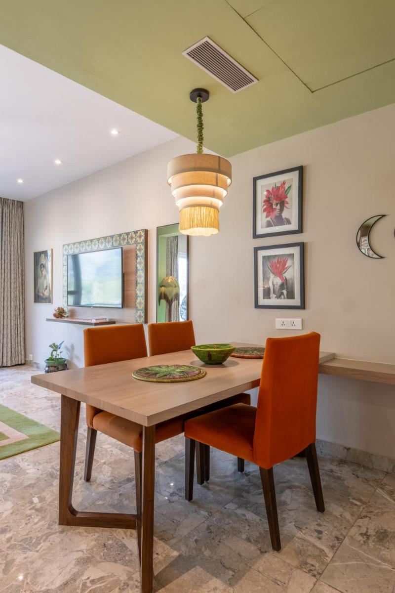 a dining room with a wooden table and orange chairs at Antalya By Divine Ganga Cottage in Rishīkesh