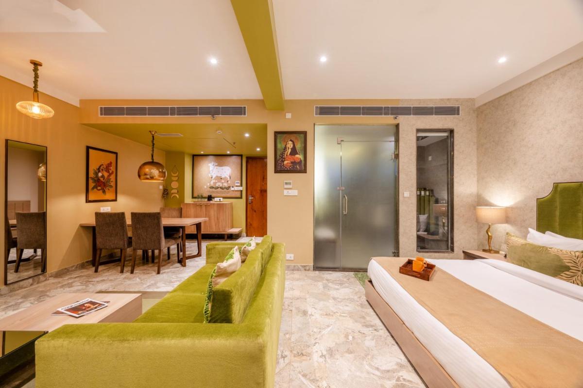 a living room with a green couch and a dining room at Antalya By Divine Ganga Cottage in Rishīkesh