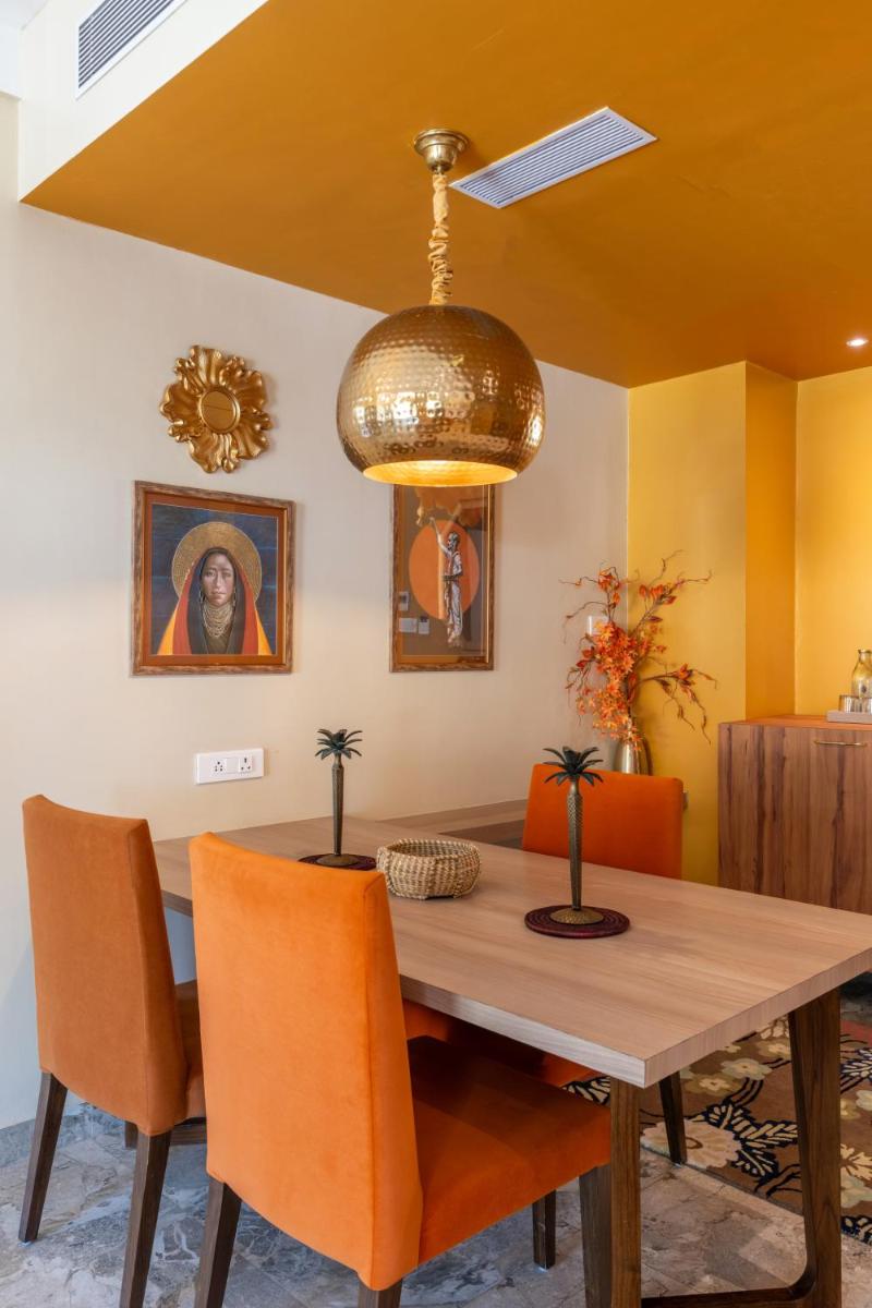a dining room with a wooden table and orange chairs at Antalya By Divine Ganga Cottage in Rishīkesh