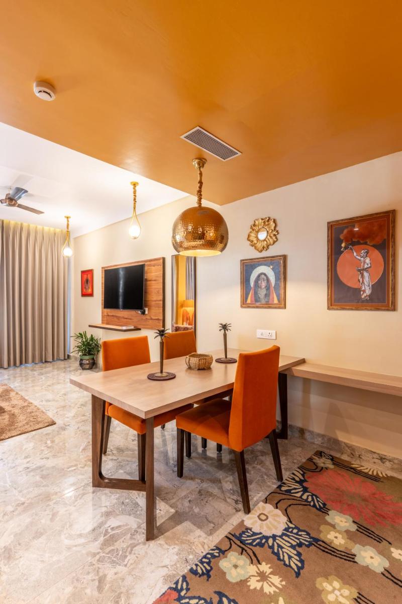 a dining room with a wooden table and orange chairs at Antalya By Divine Ganga Cottage in Rishīkesh