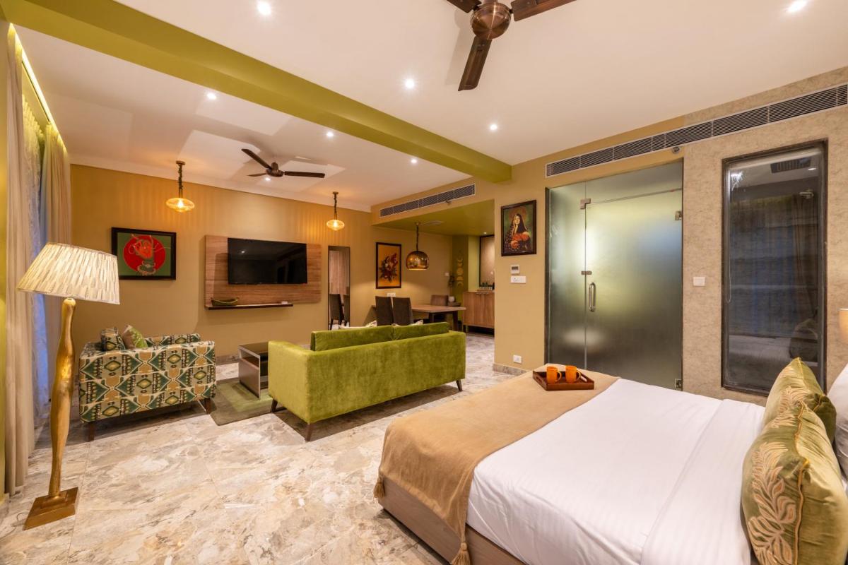 a hotel room with a bed and a living room at Antalya By Divine Ganga Cottage in Rishīkesh