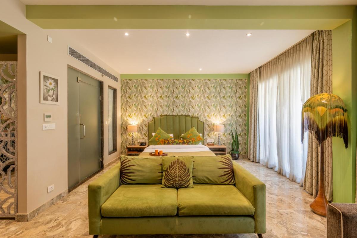 a large bedroom with a green couch in front of a bed at Antalya By Divine Ganga Cottage in Rishīkesh
