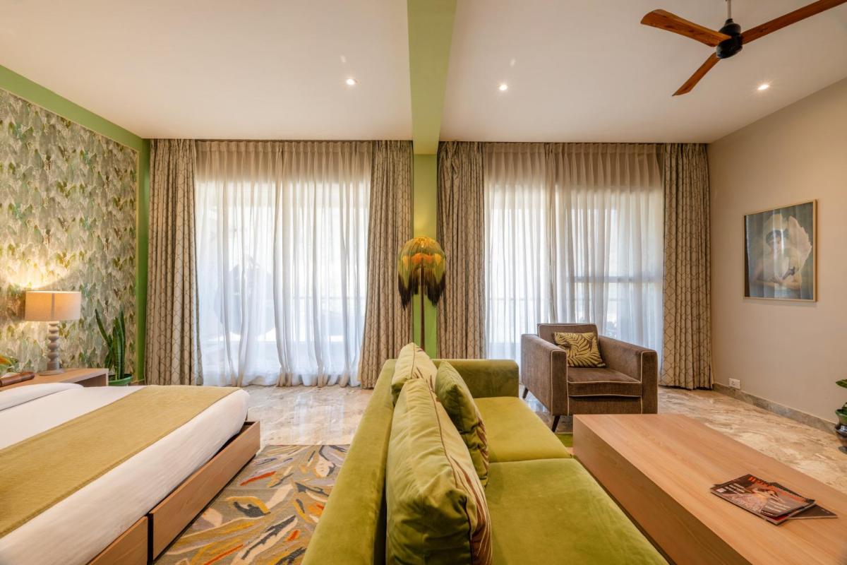 a hotel room with a bed and a couch at Antalya By Divine Ganga Cottage in Rishīkesh
