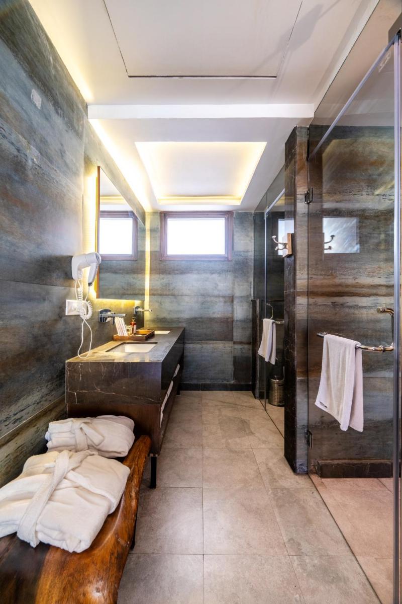 a bathroom with a sink and a bath tub and a vanity at Antalya By Divine Ganga Cottage in Rishīkesh