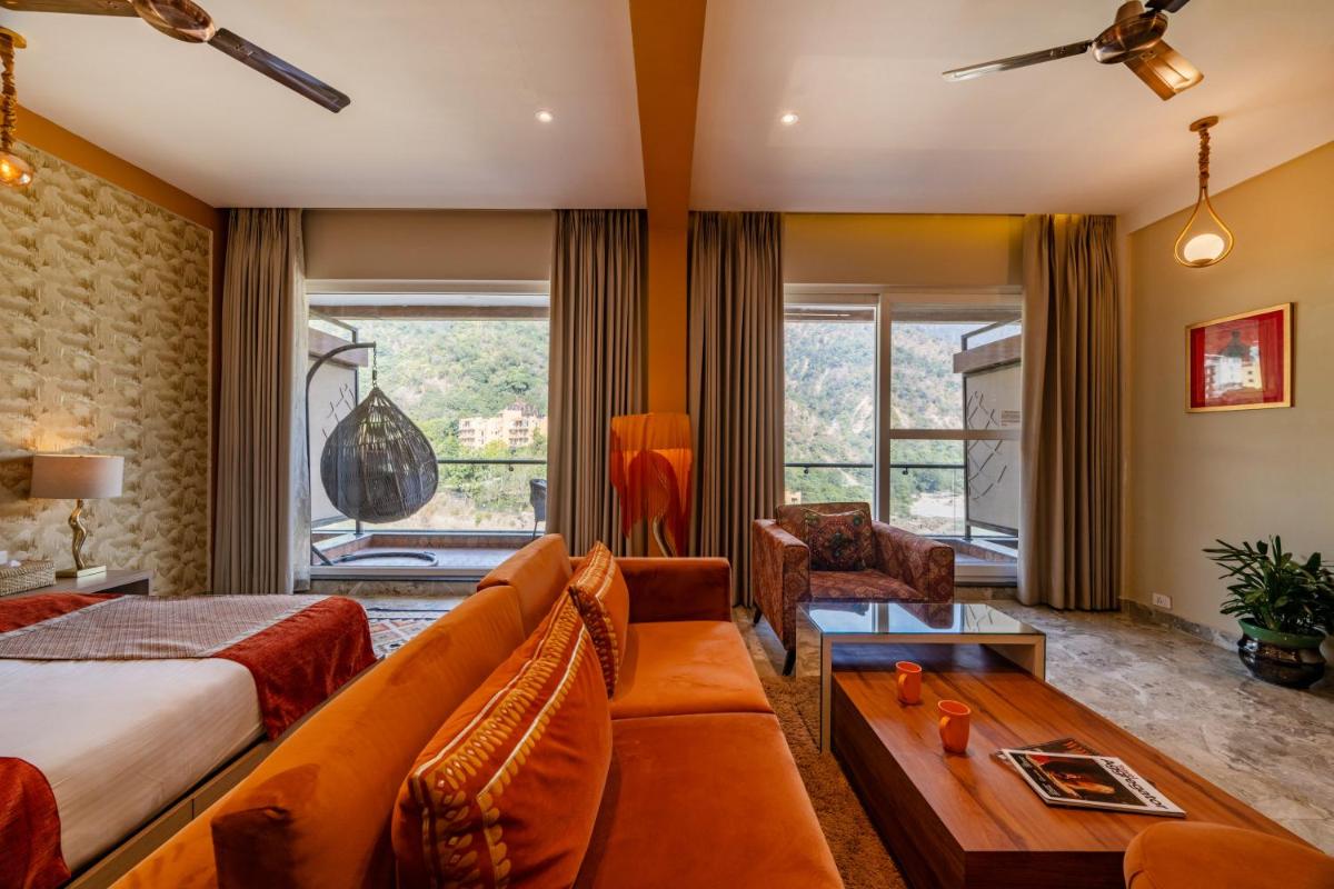 a hotel room with a bed and a couch at Antalya By Divine Ganga Cottage in Rishīkesh