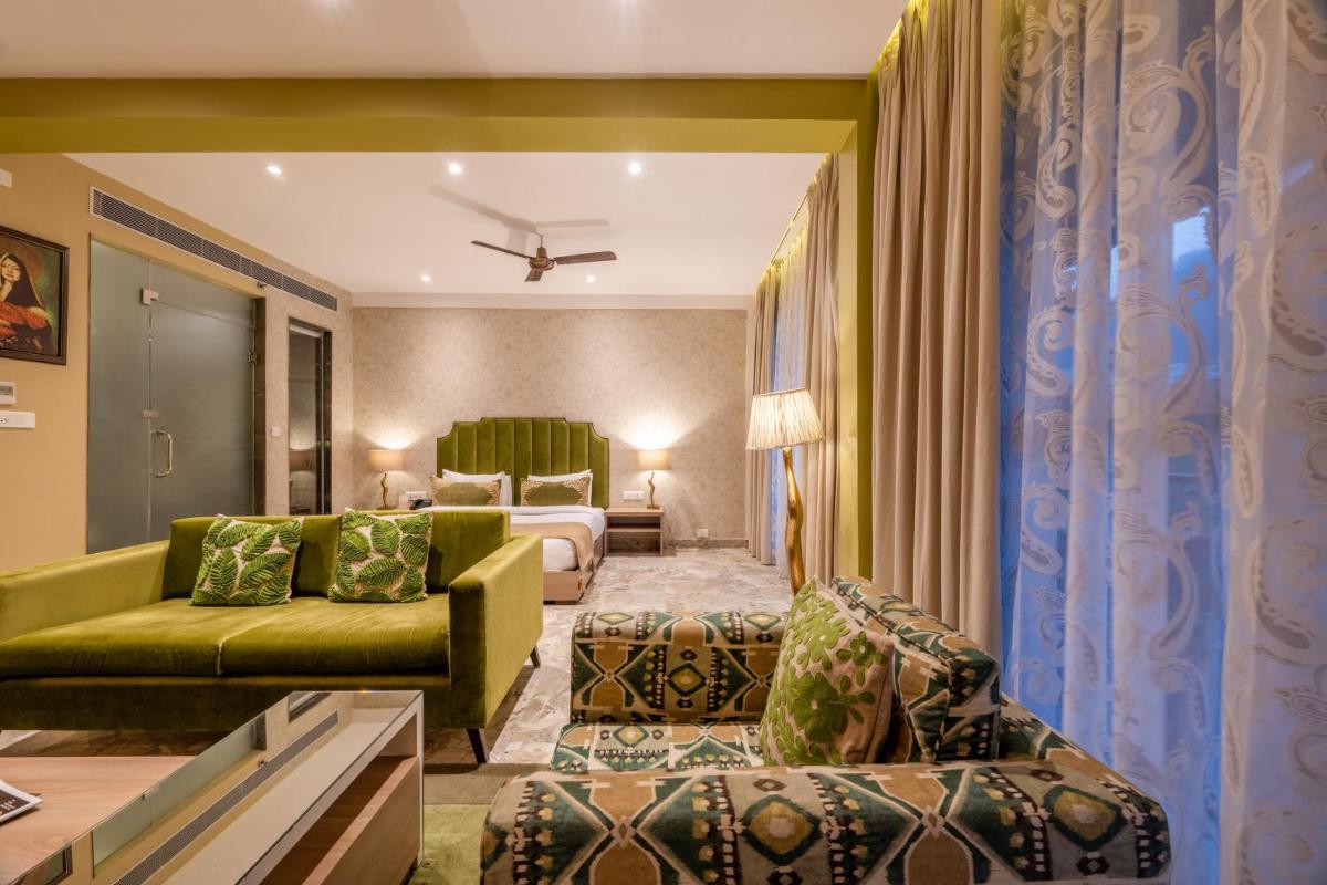 a living room with a green couch and a bed at Antalya By Divine Ganga Cottage in Rishīkesh