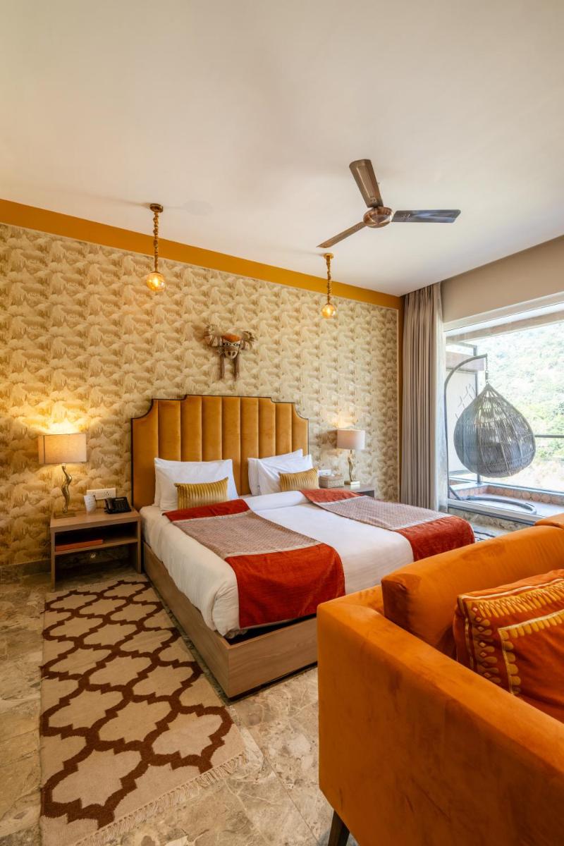 a bedroom with a large bed and a couch at Antalya By Divine Ganga Cottage in Rishīkesh