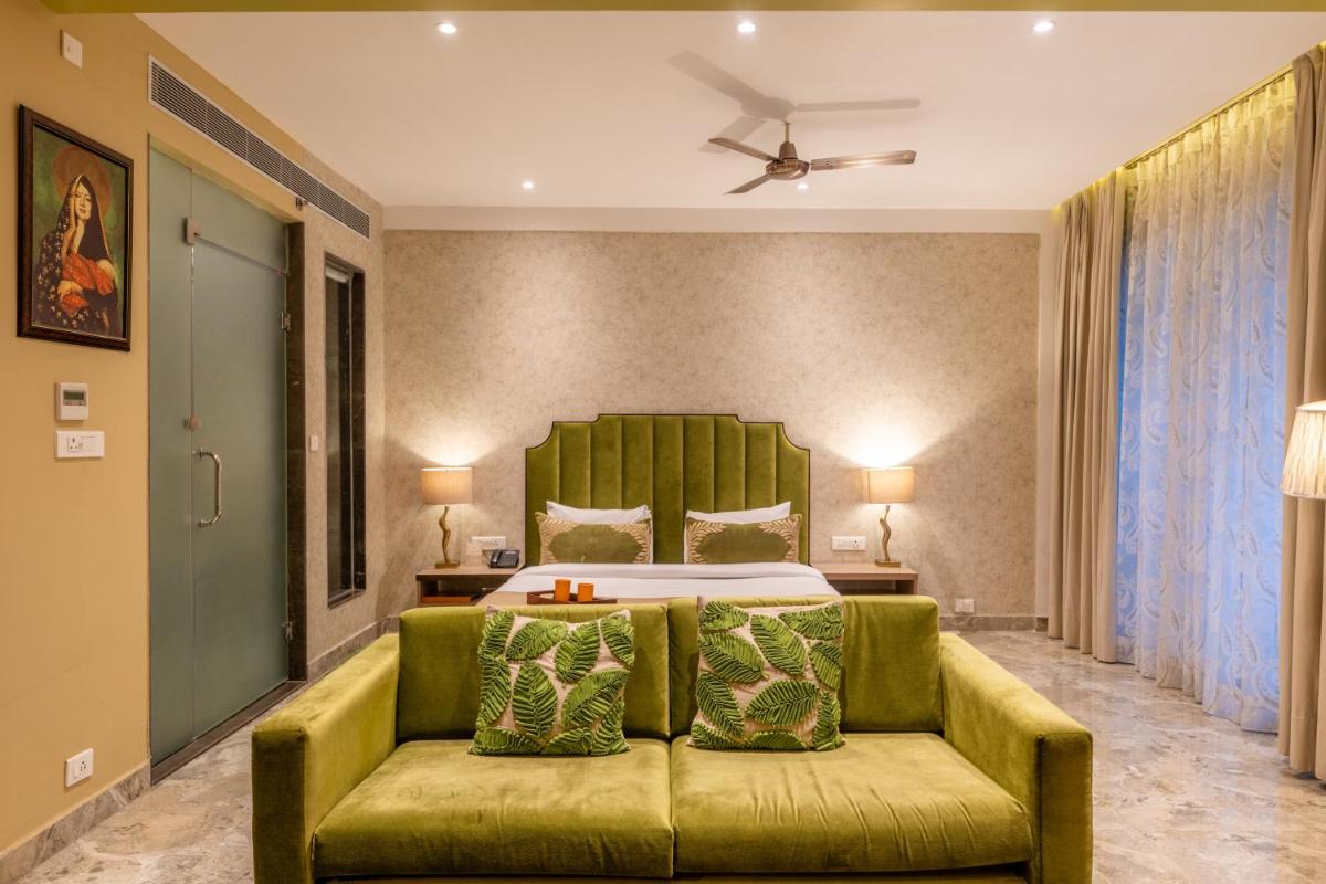 a bedroom with a green couch and a bed at Antalya By Divine Ganga Cottage in Rishīkesh