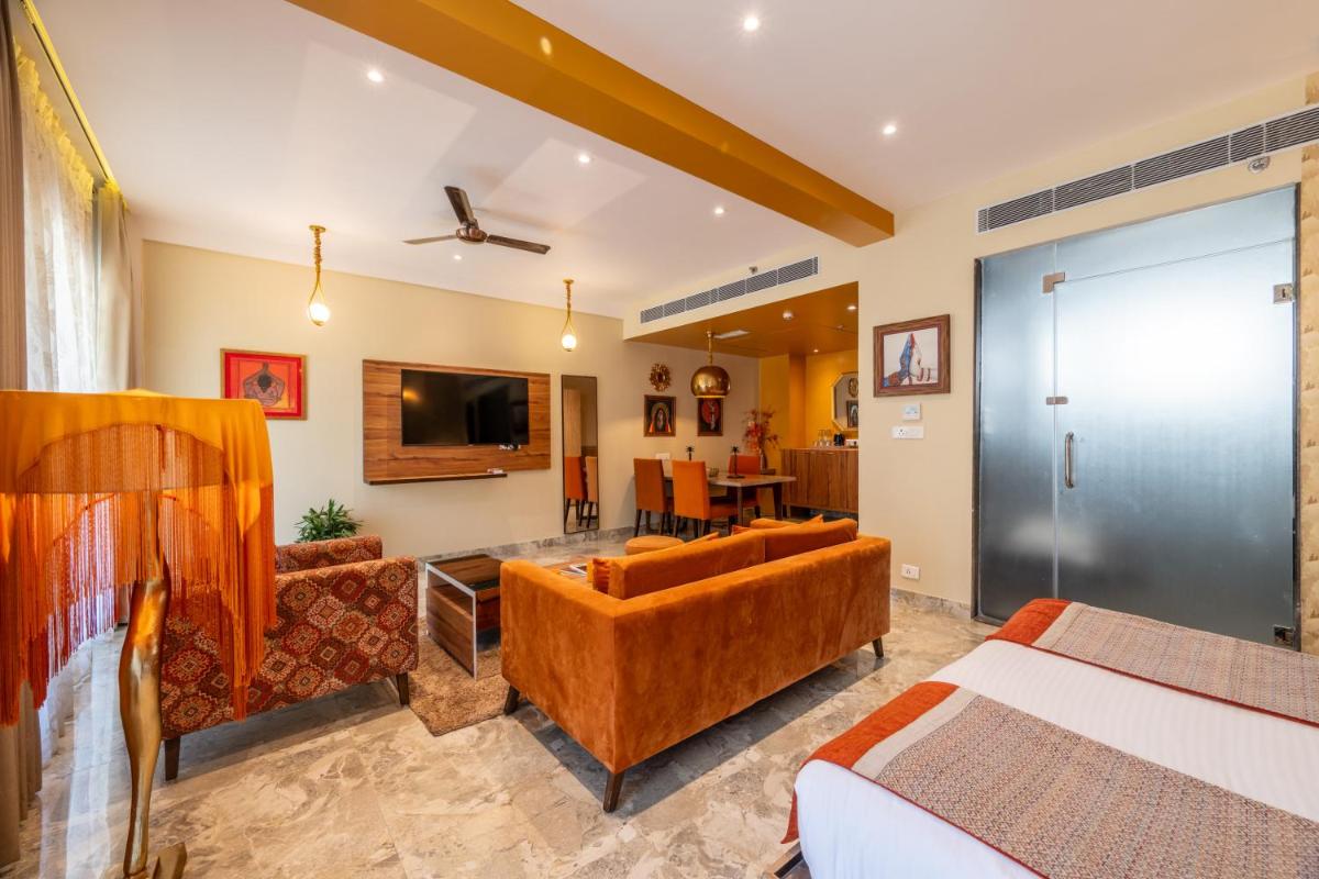 a living room with a couch and a television in a room at Antalya By Divine Ganga Cottage in Rishīkesh
