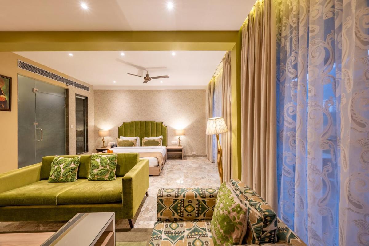 a hotel room with a bed and a couch at Antalya By Divine Ganga Cottage in Rishīkesh