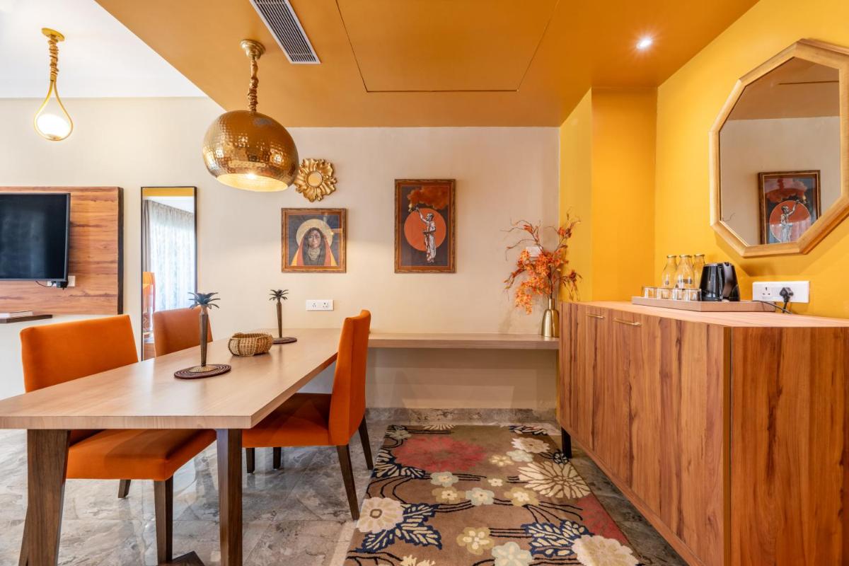 a dining room with a wooden table and yellow walls at Antalya By Divine Ganga Cottage in Rishīkesh