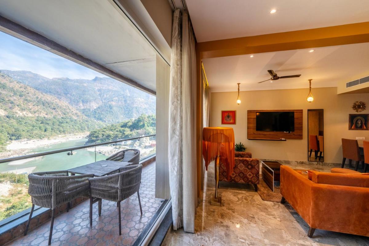 a living room with a balcony with a view at Antalya By Divine Ganga Cottage in Rishīkesh