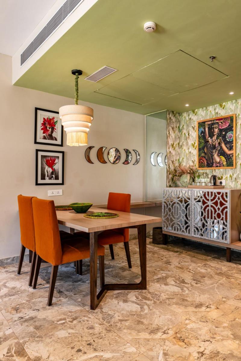 a dining room with a wooden table and orange chairs at Antalya By Divine Ganga Cottage in Rishīkesh
