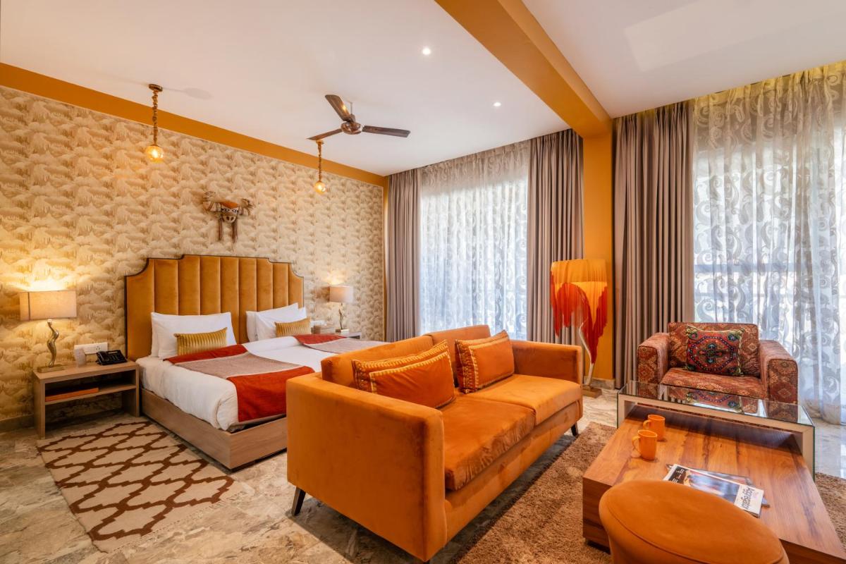 a hotel room with a bed and a couch at Antalya By Divine Ganga Cottage in Rishīkesh