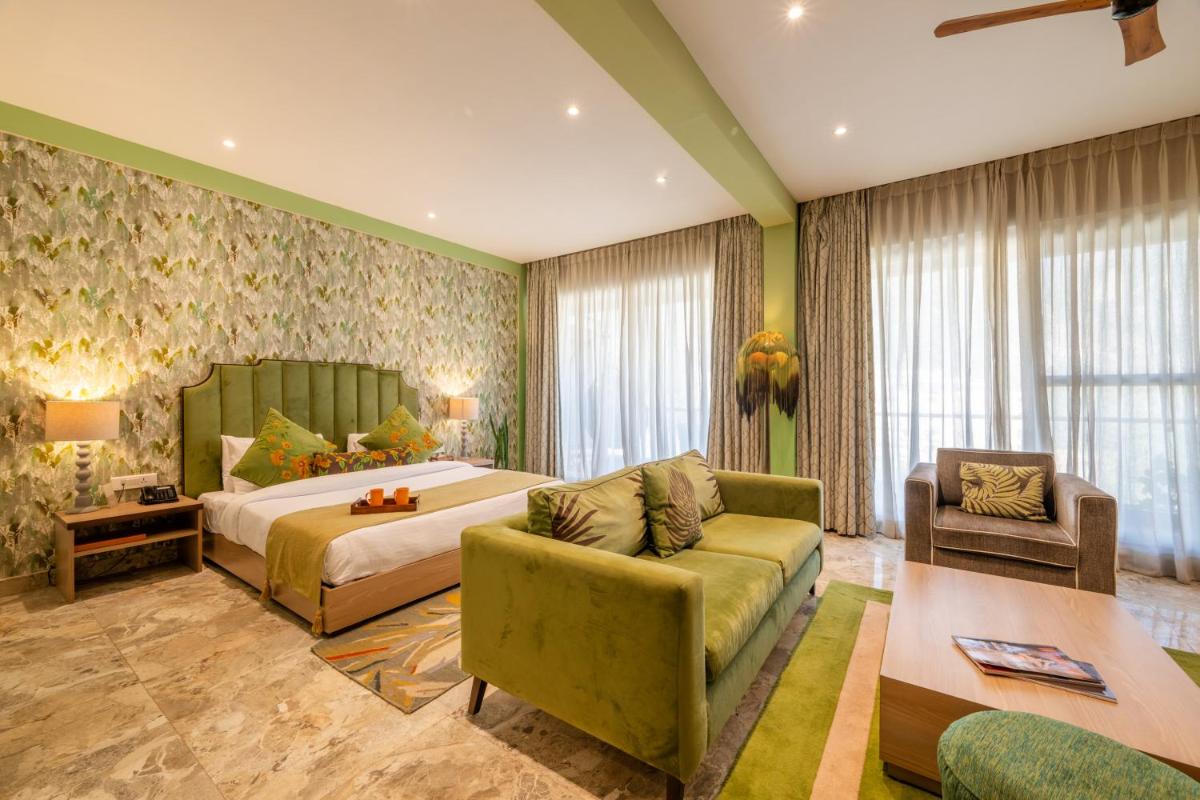 a hotel room with a bed and a couch at Antalya By Divine Ganga Cottage in Rishīkesh