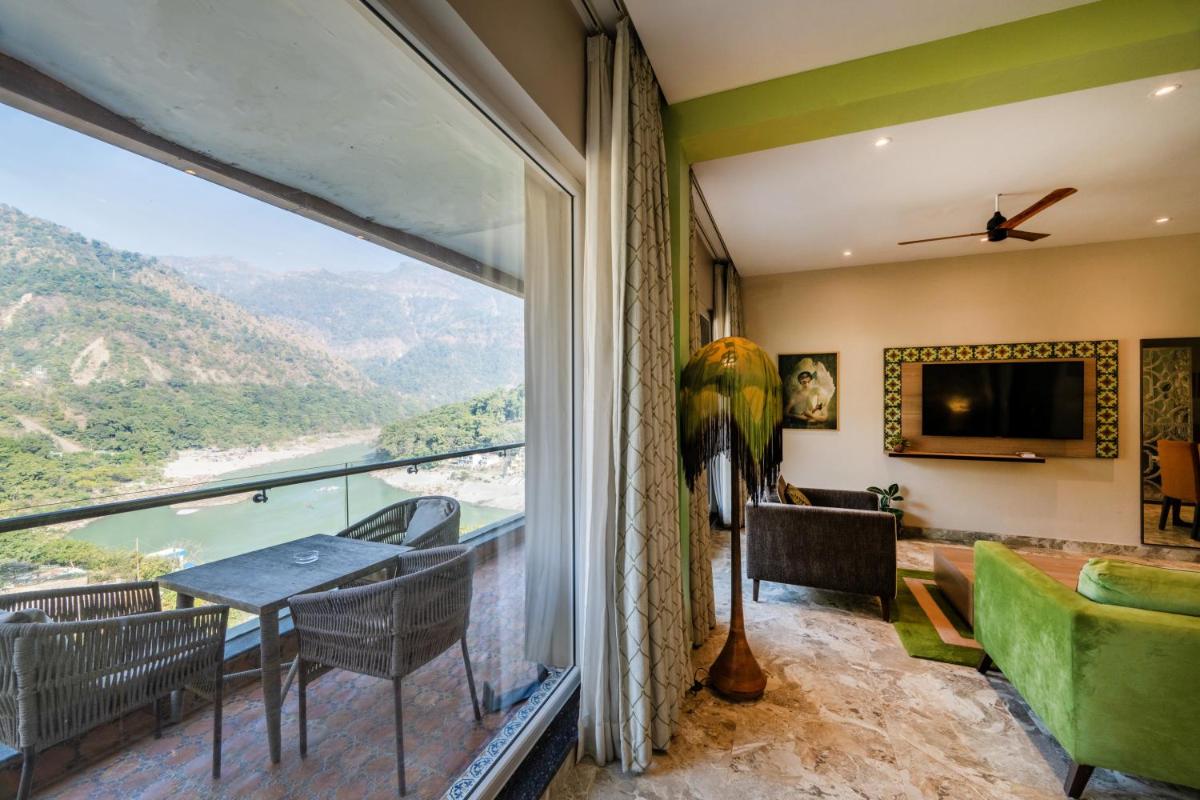 a living room with a large window and a table and chairs at Antalya By Divine Ganga Cottage in Rishīkesh