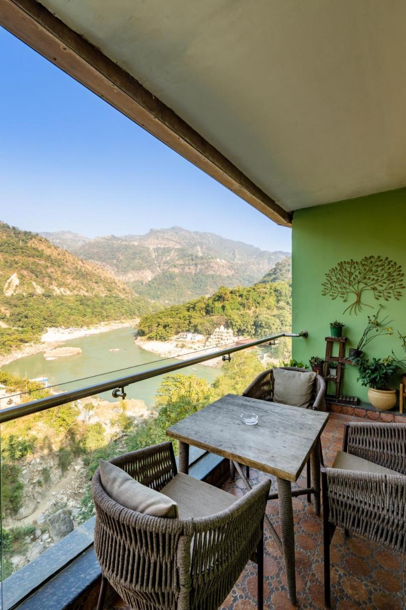 a balcony with a table and chairs and a view at Antalya By Divine Ganga Cottage in Rishīkesh