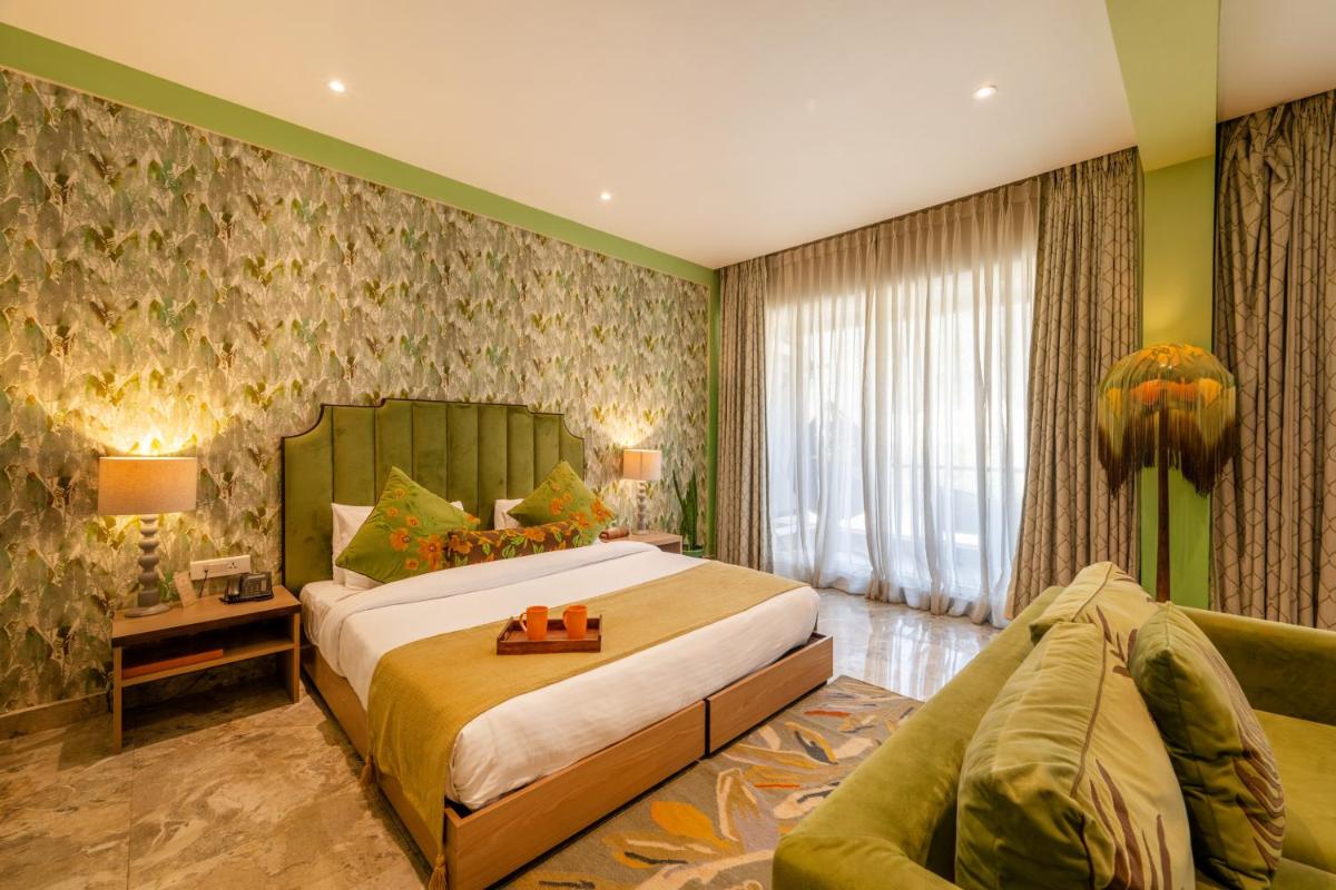 a bedroom with a large bed and a couch at Antalya By Divine Ganga Cottage in Rishīkesh