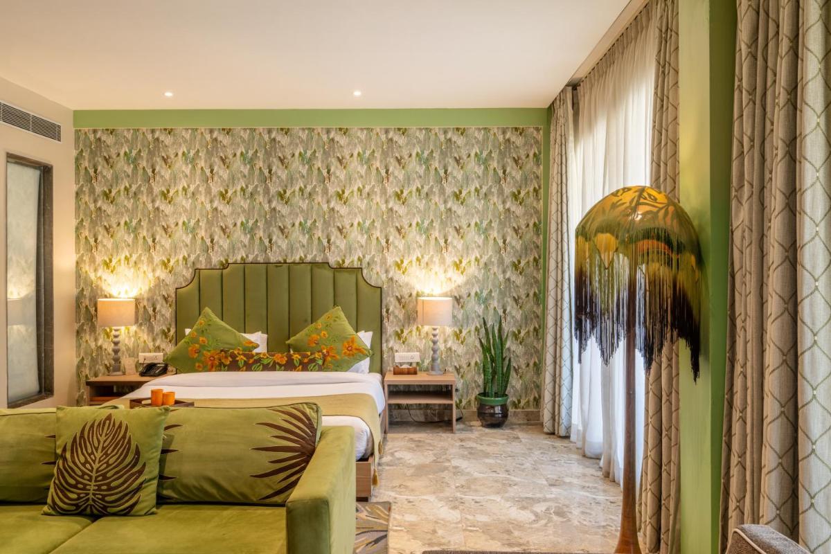 a hotel room with a bed and a couch at Antalya By Divine Ganga Cottage in Rishīkesh