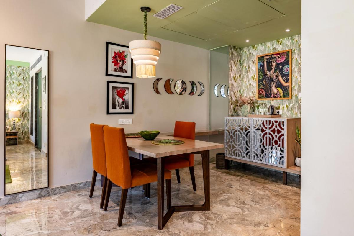 a dining room with a wooden table and orange chairs at Antalya By Divine Ganga Cottage in Rishīkesh