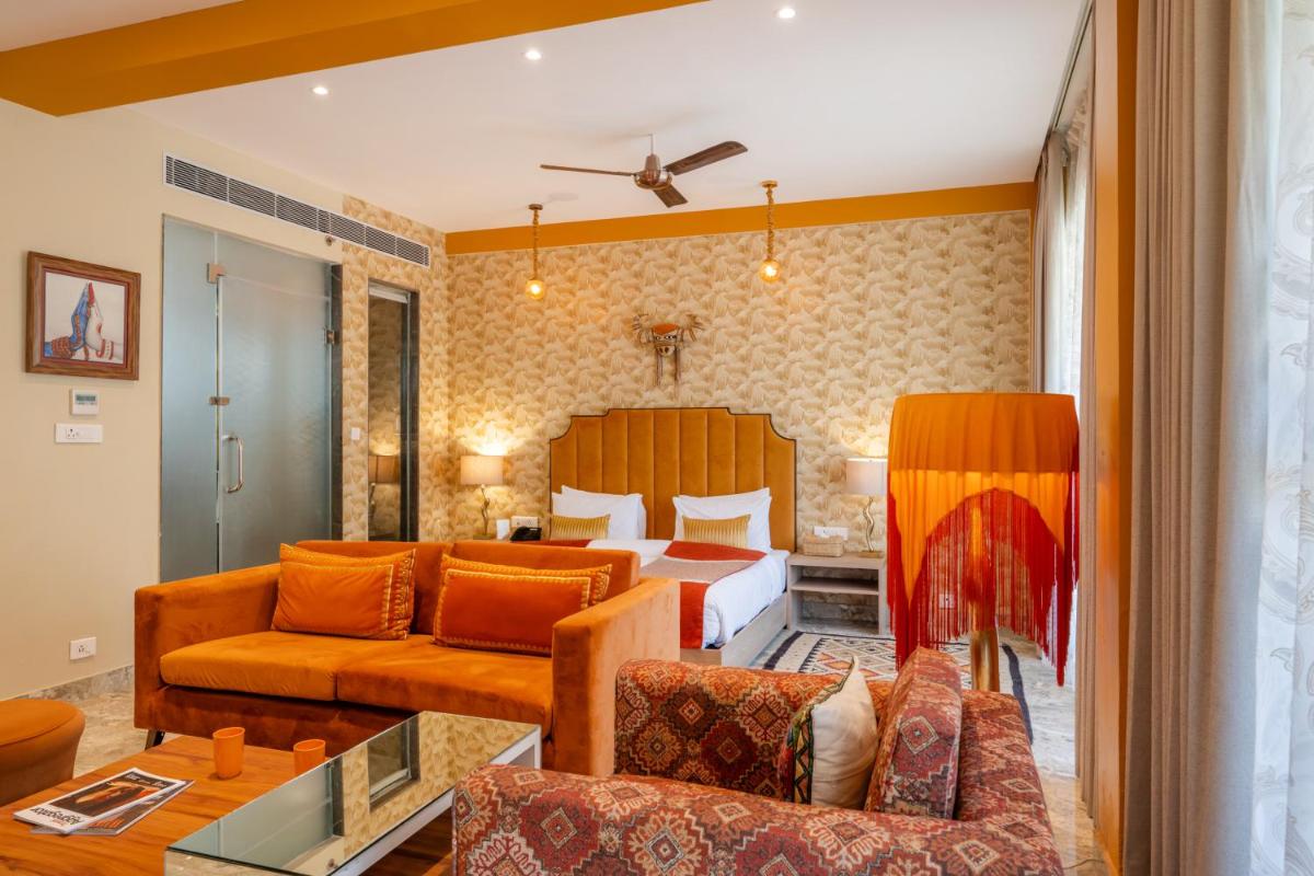 a hotel room with a bed and a couch at Antalya By Divine Ganga Cottage in Rishīkesh