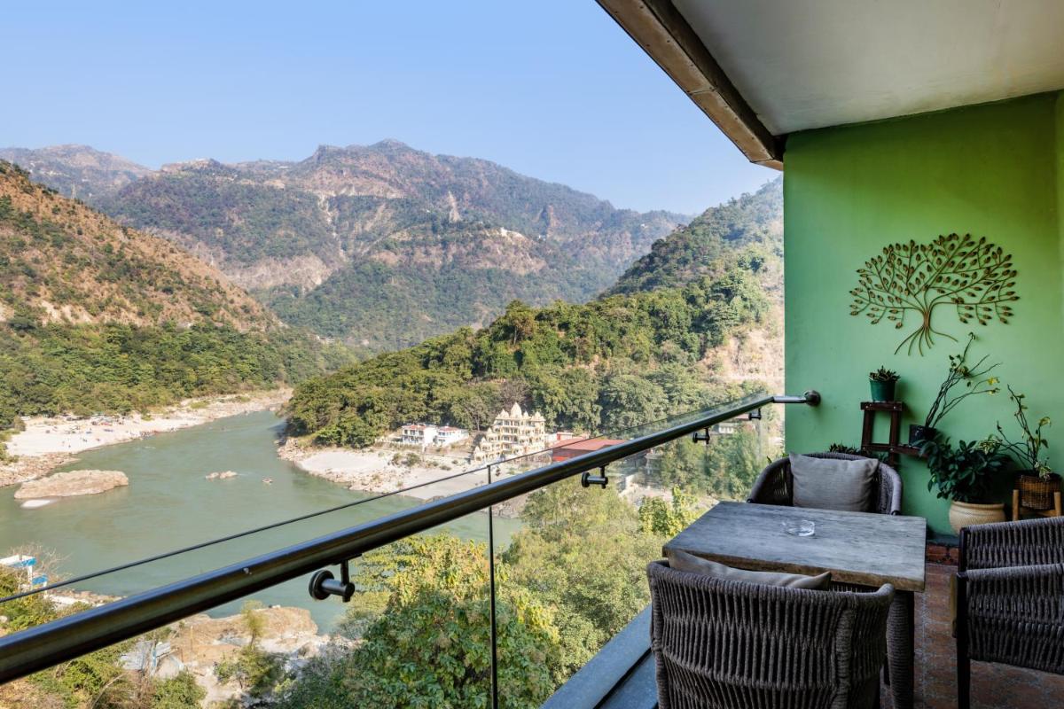 a balcony with a view of a river and mountains at Antalya By Divine Ganga Cottage in Rishīkesh