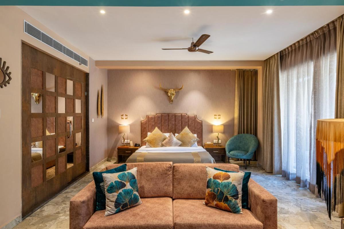 a hotel room with a bed and a couch at Antalya By Divine Ganga Cottage in Rishīkesh