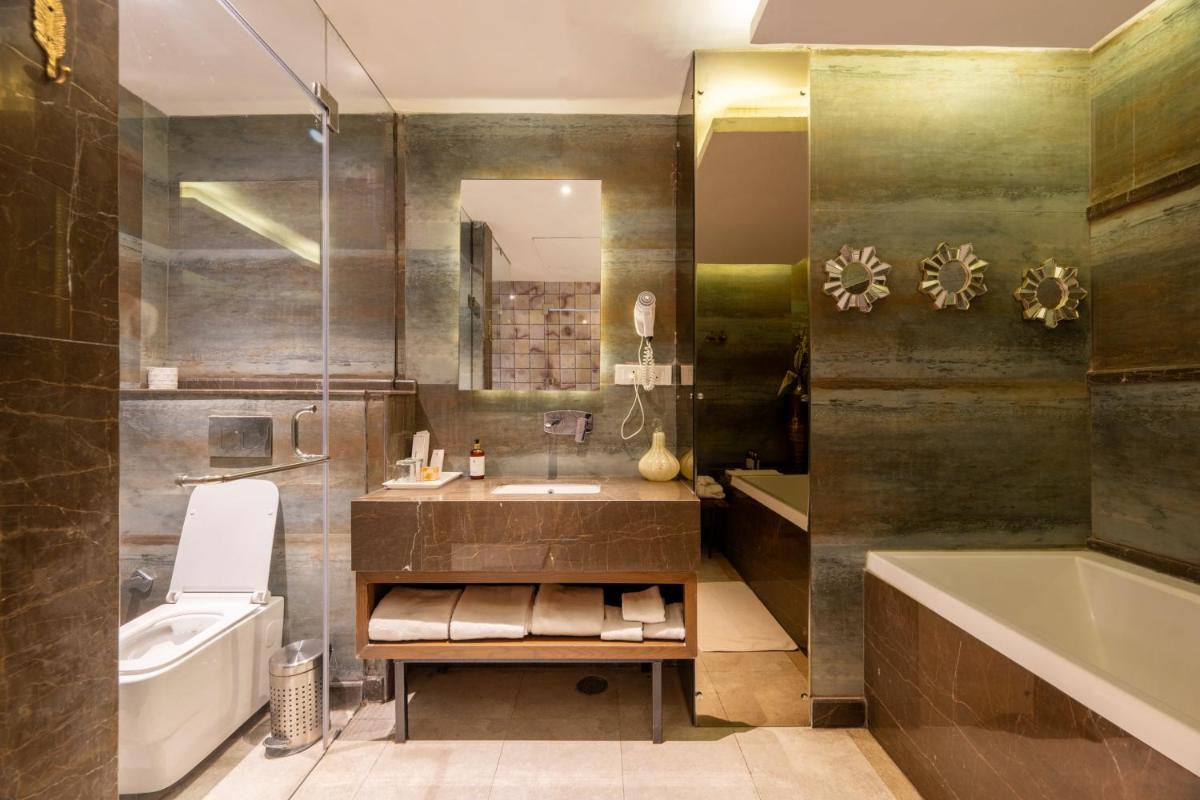 a bathroom with a sink and a tub and a toilet at Antalya By Divine Ganga Cottage in Rishīkesh
