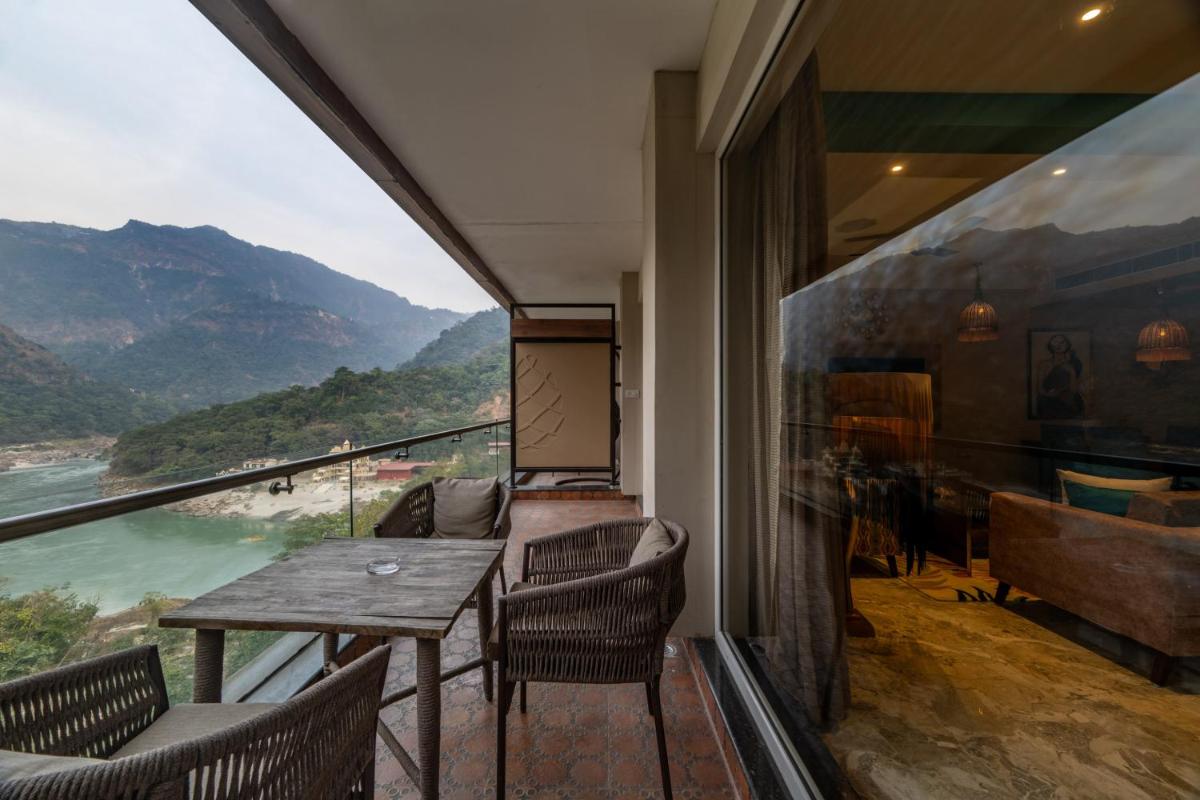 a balcony with a table and chairs and a view at Antalya By Divine Ganga Cottage in Rishīkesh