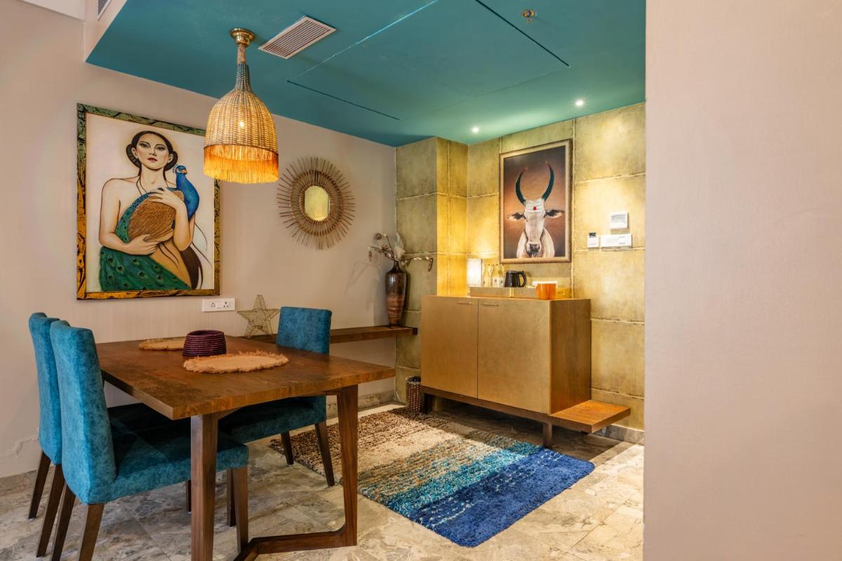 a dining room with a table and blue chairs at Antalya By Divine Ganga Cottage in Rishīkesh