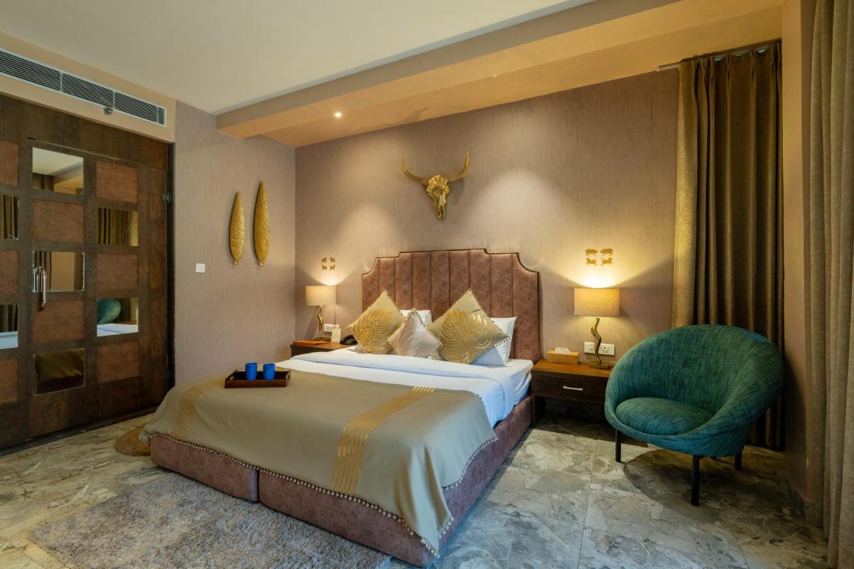 a hotel room with a bed and a chair at Antalya By Divine Ganga Cottage in Rishīkesh