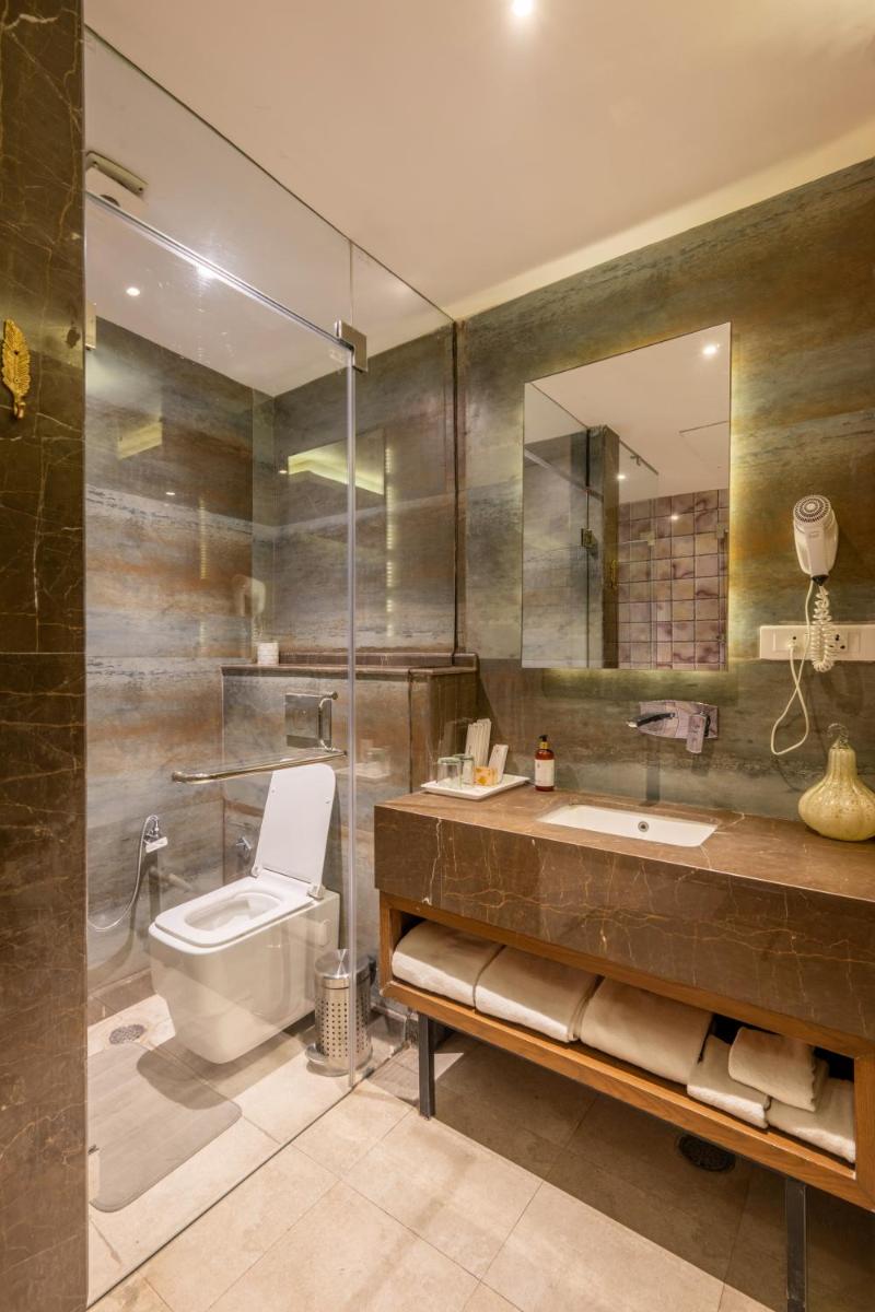 a bathroom with a toilet and a sink and a mirror at Antalya By Divine Ganga Cottage in Rishīkesh