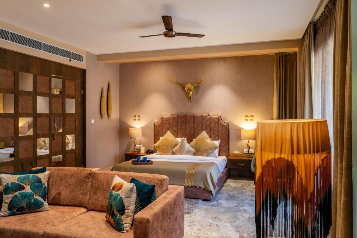 a hotel room with a bed and a couch at Antalya By Divine Ganga Cottage in Rishīkesh