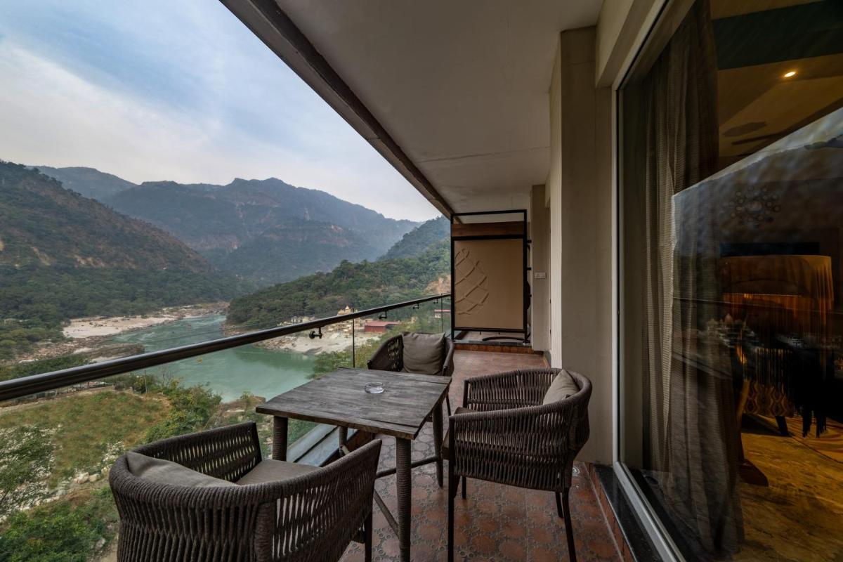 a balcony with a table and chairs and a view at Antalya By Divine Ganga Cottage in Rishīkesh
