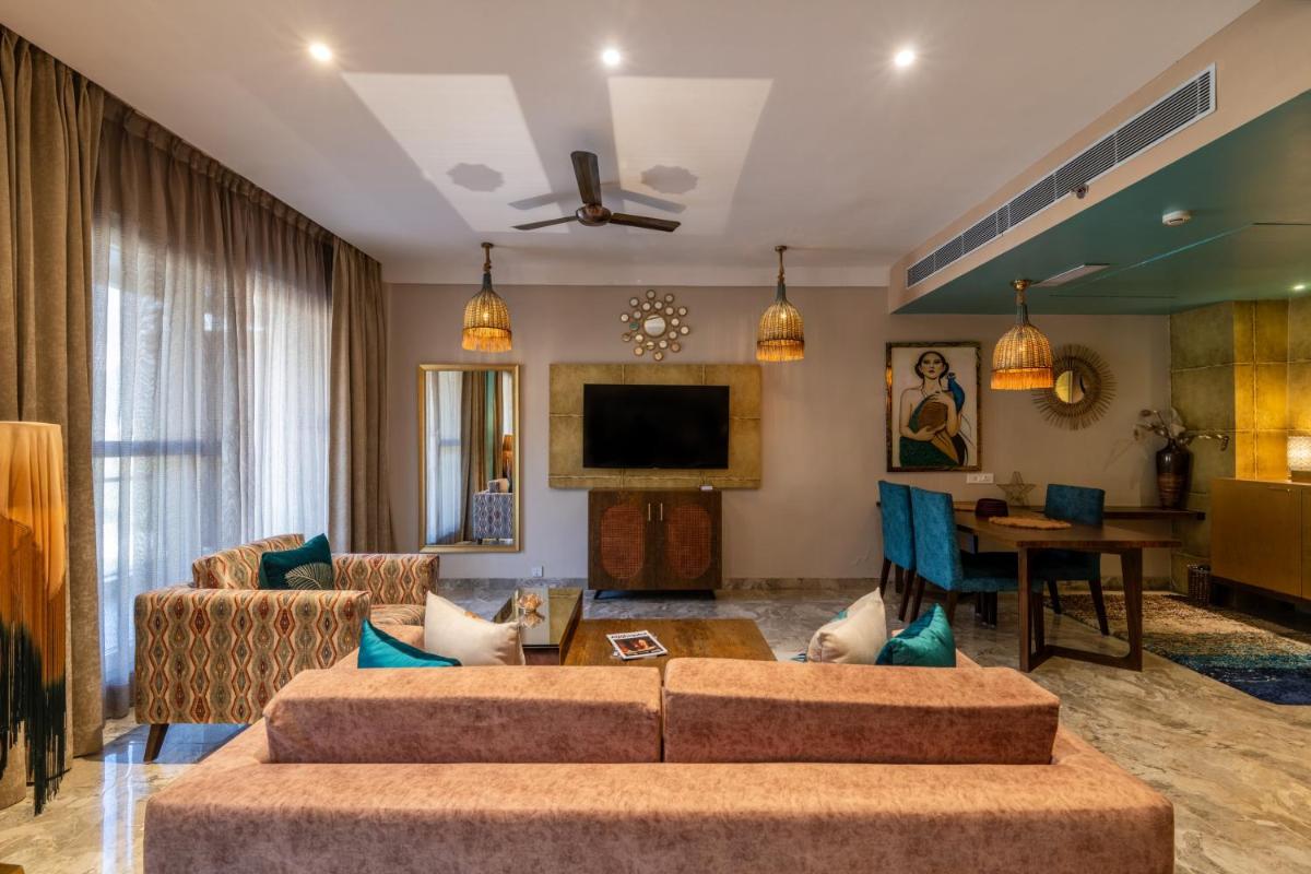 a living room with two couches and a tv at Antalya By Divine Ganga Cottage in Rishīkesh