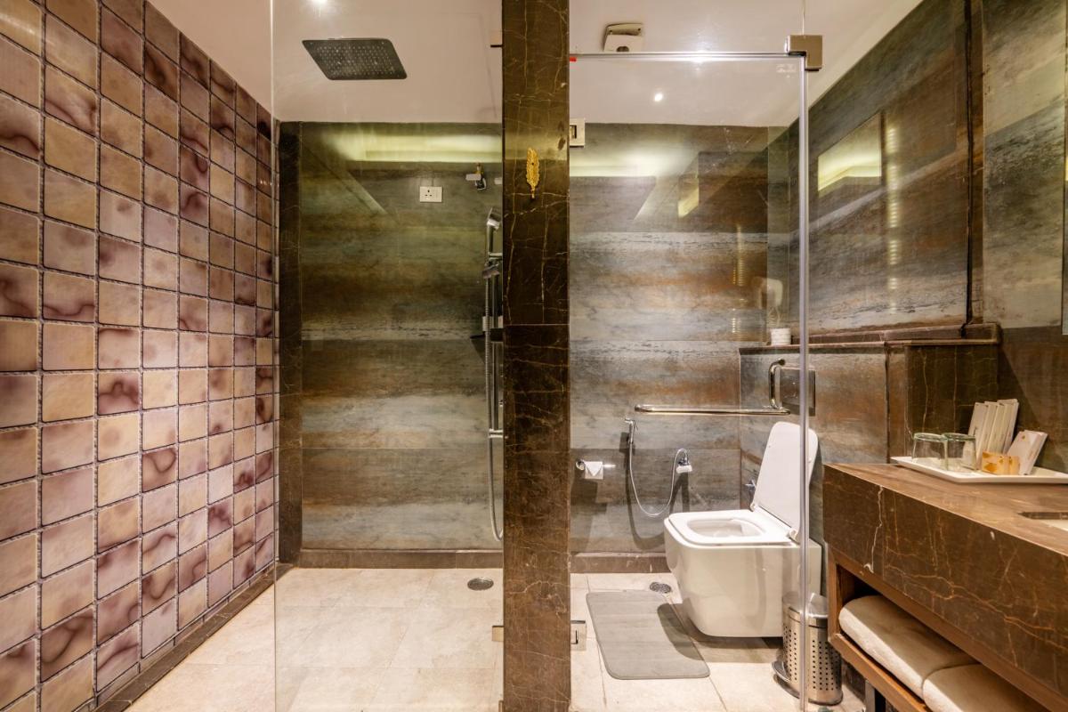a bathroom with a toilet and a glass shower at Antalya By Divine Ganga Cottage in Rishīkesh