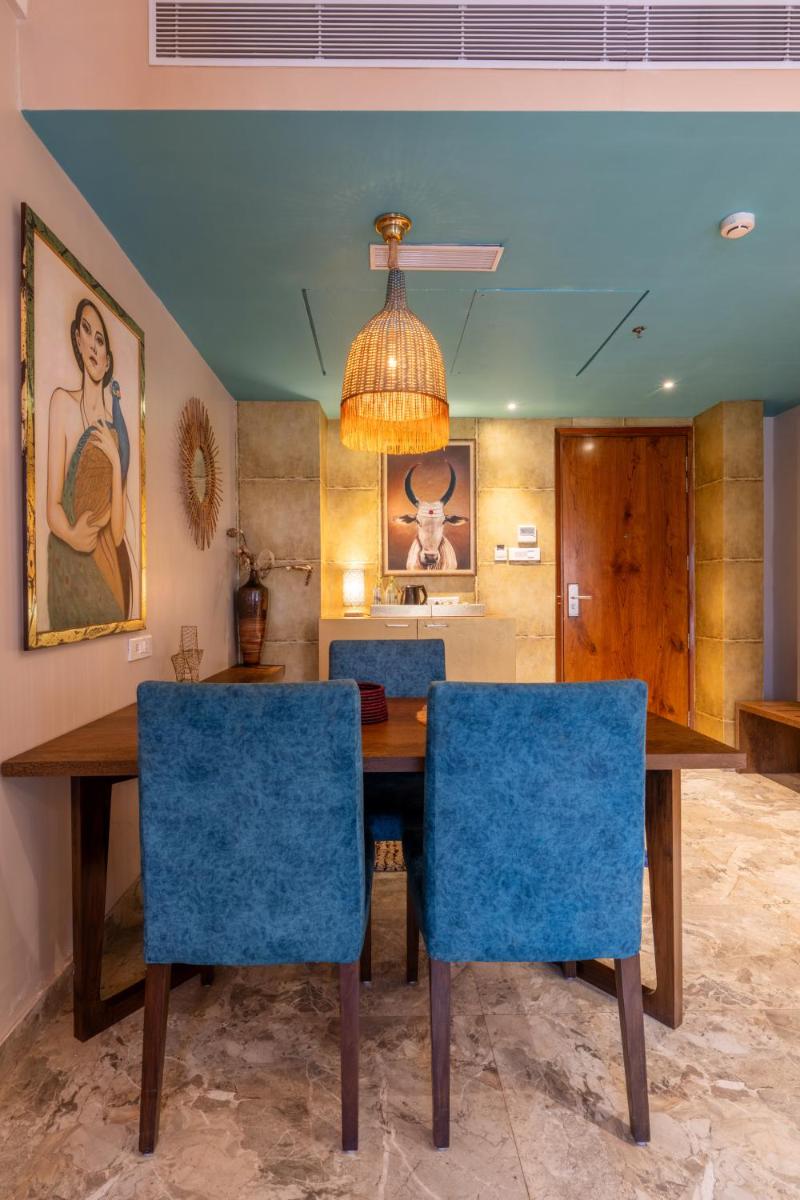 a dining room with a table and blue chairs at Antalya By Divine Ganga Cottage in Rishīkesh