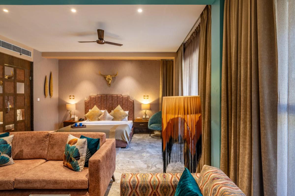 a hotel room with a bed and a couch at Antalya By Divine Ganga Cottage in Rishīkesh