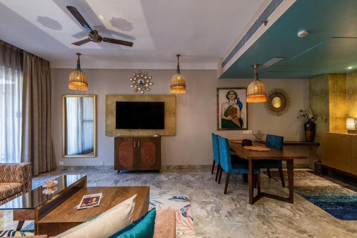 a living room with a table and a tv at Antalya By Divine Ganga Cottage in Rishīkesh