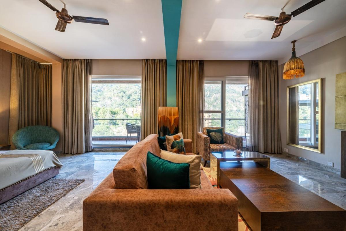 a living room with a couch and a bed at Antalya By Divine Ganga Cottage in Rishīkesh