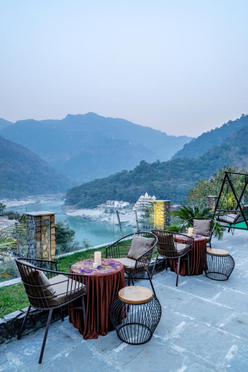 a group of tables and chairs on a patio with a view at Antalya By Divine Ganga Cottage in Rishīkesh