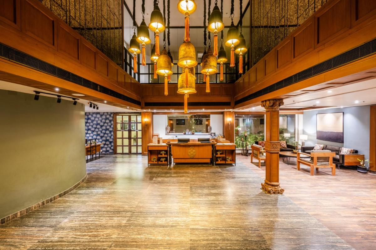 a large room with tables and chairs and chandeliers at Antalya By Divine Ganga Cottage in Rishīkesh