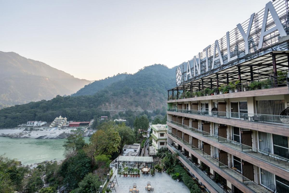 a building with a view of a river and mountains at Antalya By Divine Ganga Cottage in Rishīkesh