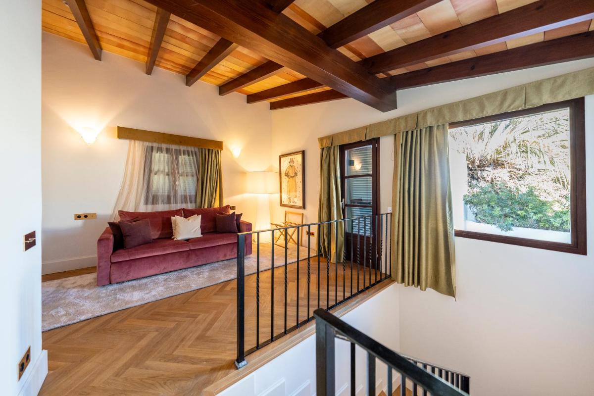 Una sala de estar con un sofá rojo y una ventana. en Palacio Ca Sa Galesa, en Palma de Mallorca