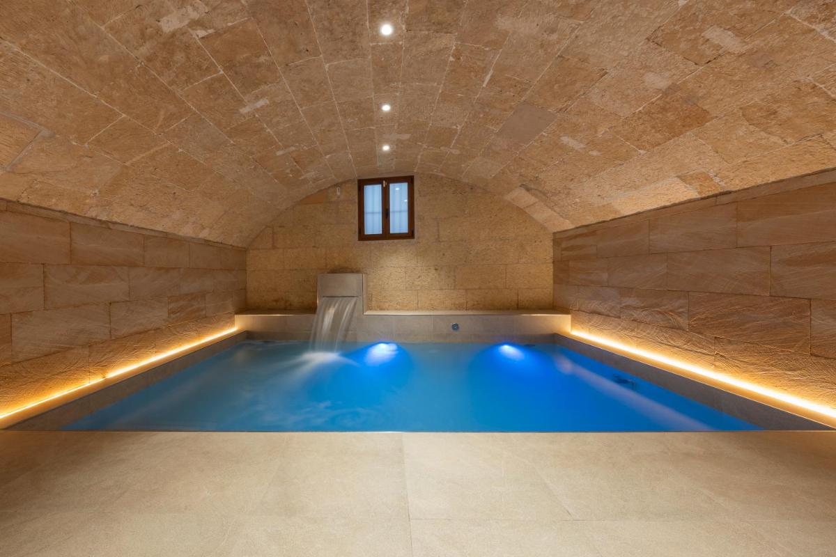 Una gran piscina en una habitación con techo de piedra. en Palacio Ca Sa Galesa, en Palma de Mallorca