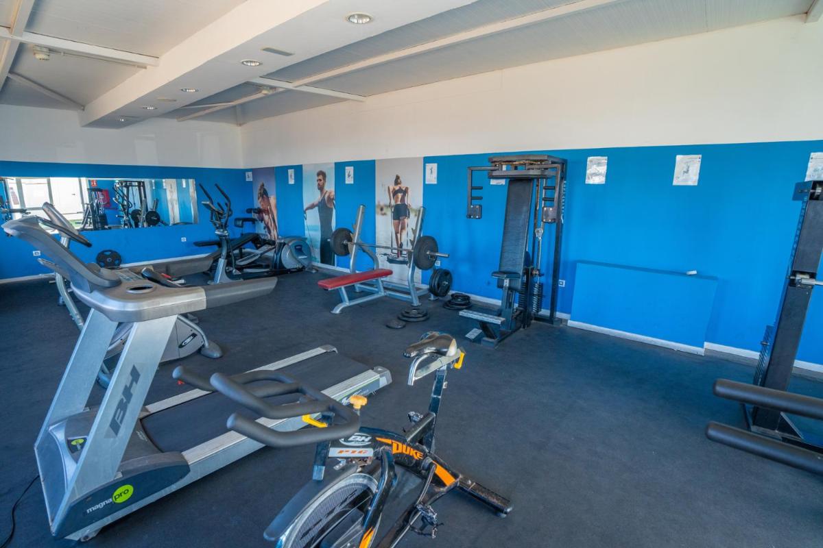 un gimnasio con paredes azules y una bicicleta en una habitación en Hotel Arena Beach, en Corralejo