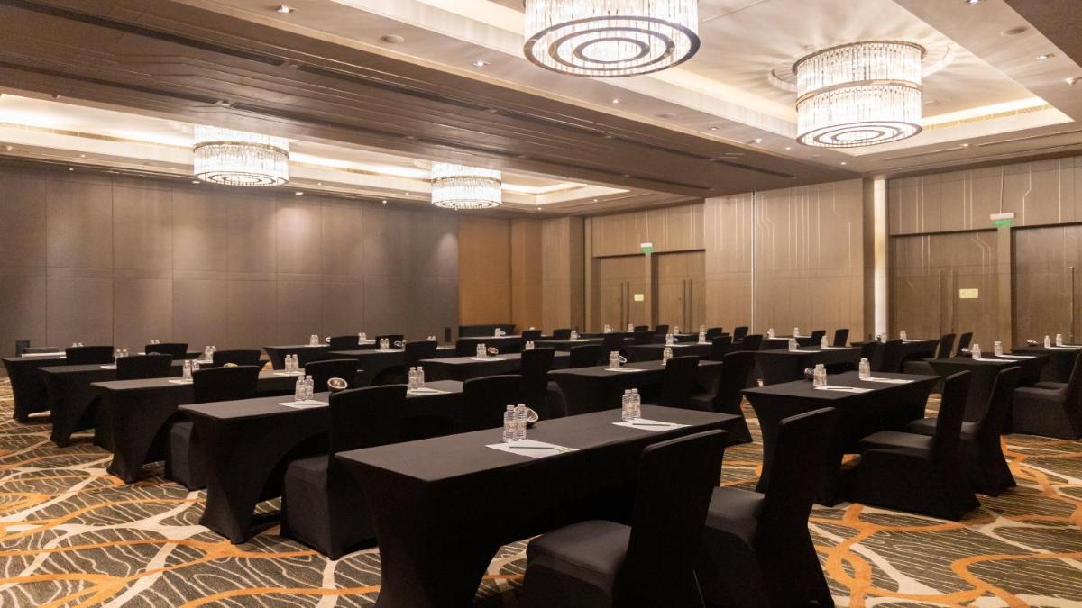 a conference room with tables and chairs and chandeliers at Holiday Inn New Delhi Aerocity by IHG in New Delhi